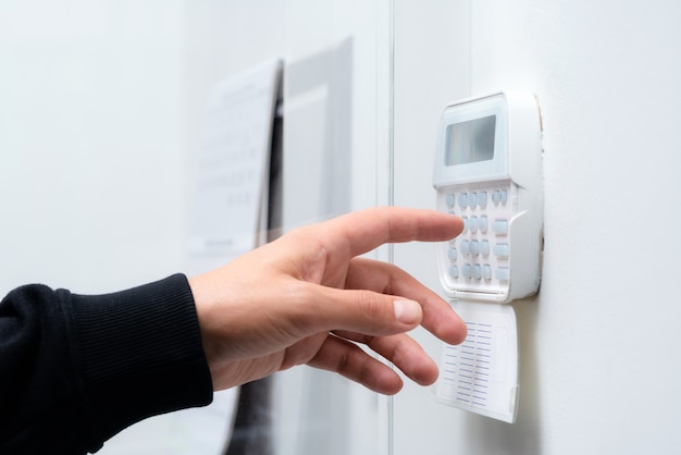 Premium Photo | Hand entering alarm system password of an apartment ...