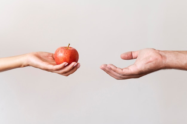 premium-photo-hand-giving-an-apple-to-needy-person