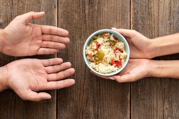 free-photo-hand-giving-bowl-of-food-to-needy-person