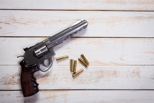 Premium Photo | Hand gun with rounds on wooden desk