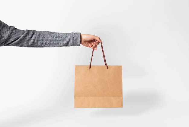 Download Hand holding blank brown paper bag for mockup template ...