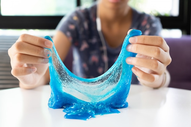 Premium Photo | Hand holding dark blue slime on white table