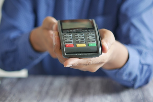 Premium Photo | Hand holding pos machine close up