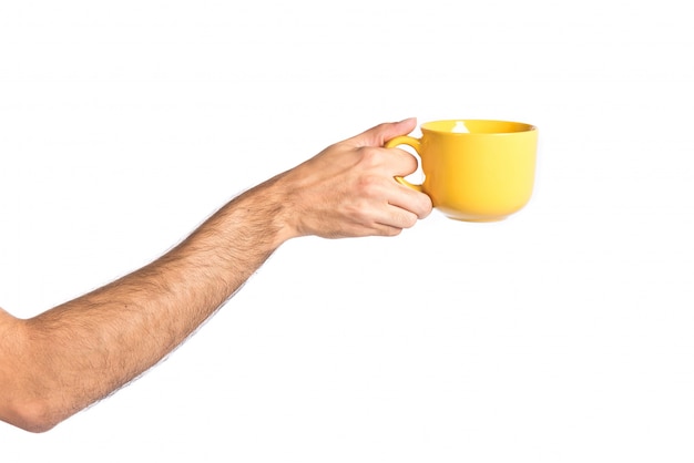 Free Photo Hand Holding A Yellow Coffee Cup Over White