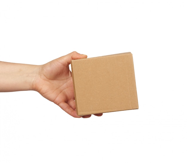 Download Premium Photo | Hand holds a brown cardboard box of paper ...