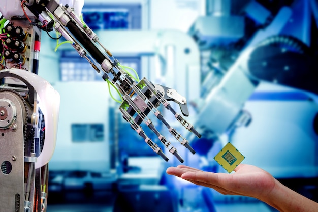 Hand of male engineer who sending cpu processor to robot for upgrade to work more efficiently Premium Photo