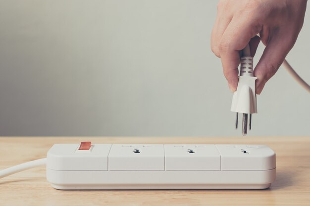 Premium Photo | Hand of male or female unplugged plug into socket to ...