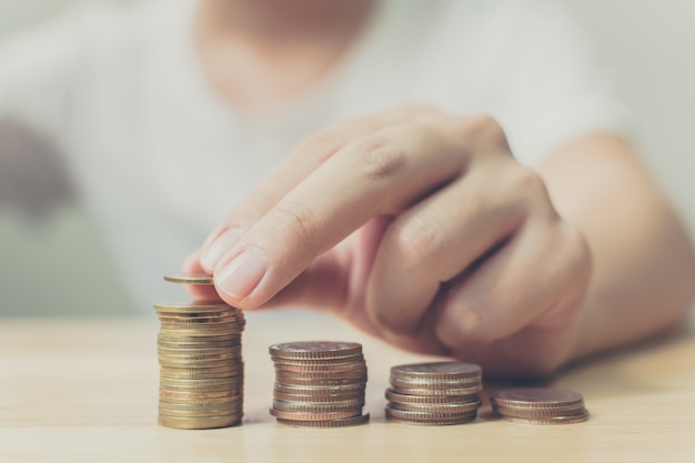 Hand of male putting gold coin stack Premium Photo