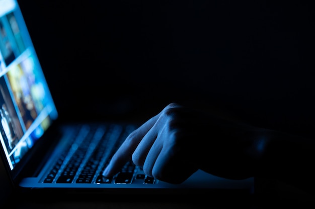 Premium Photo | Hand of a man using laptop computer in the dark