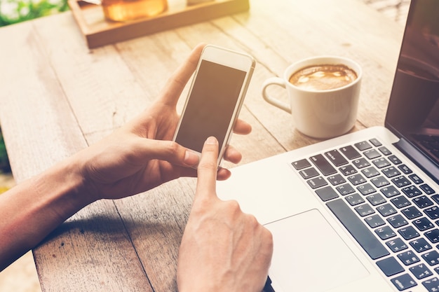 Premium Photo | Hand man using phone and laptop in coffee shop.