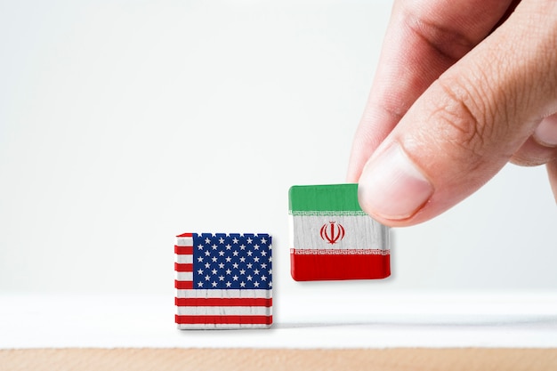 手書きの印刷画面イラン国旗とアメリカ国旗の木の立方体 それはアメリカ合衆国とイランの象徴であり 核兵器とホルムズ海峡で対立があります プレミアム写真