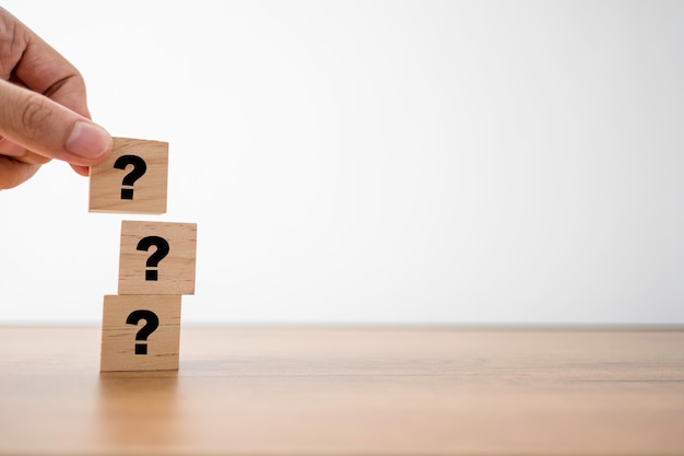 Premium Photo | Hand putting question mark on wooden cubes for q&a or ...