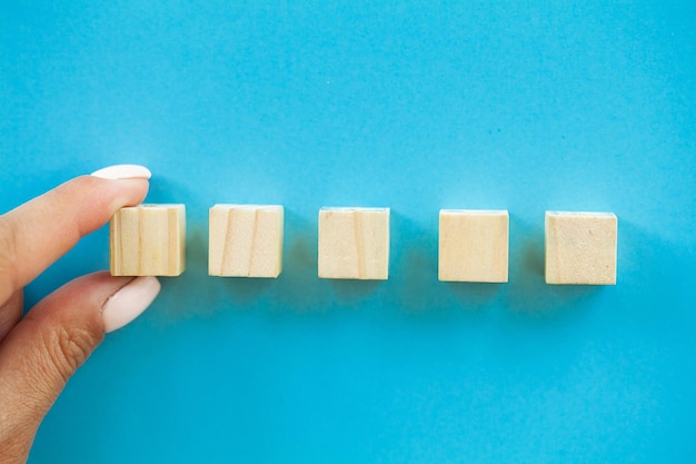 Premium Photo | Hand putting and stacking blank wooden cubes