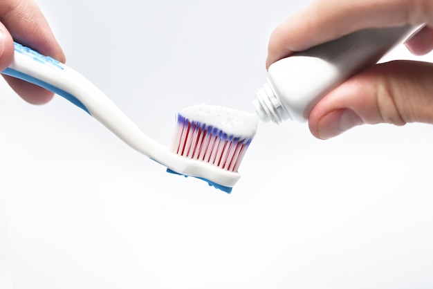 putting toothpaste on toothbrush