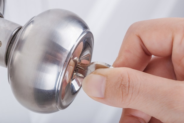 Hand Use The Key For Unlocking Door Knob On White Door Photo