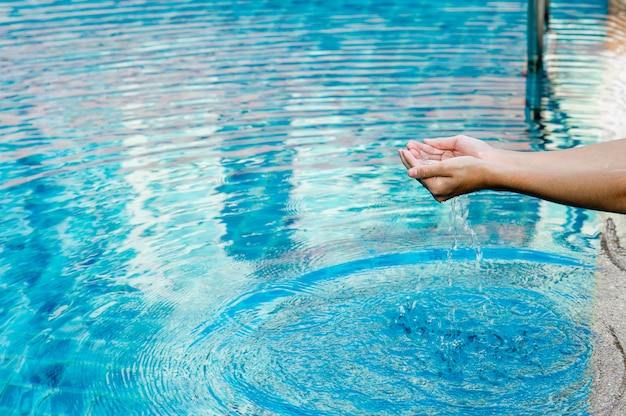 Premium Photo | Hand and water touch the blue water. to refresh the ...