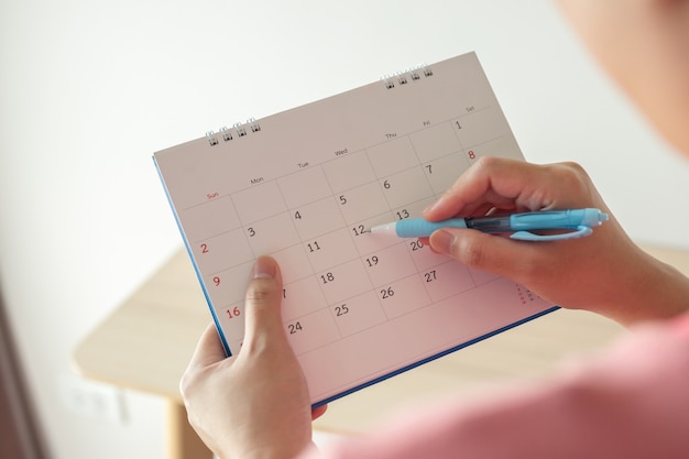 Premium Photo | Hand with pen writing on calendar date