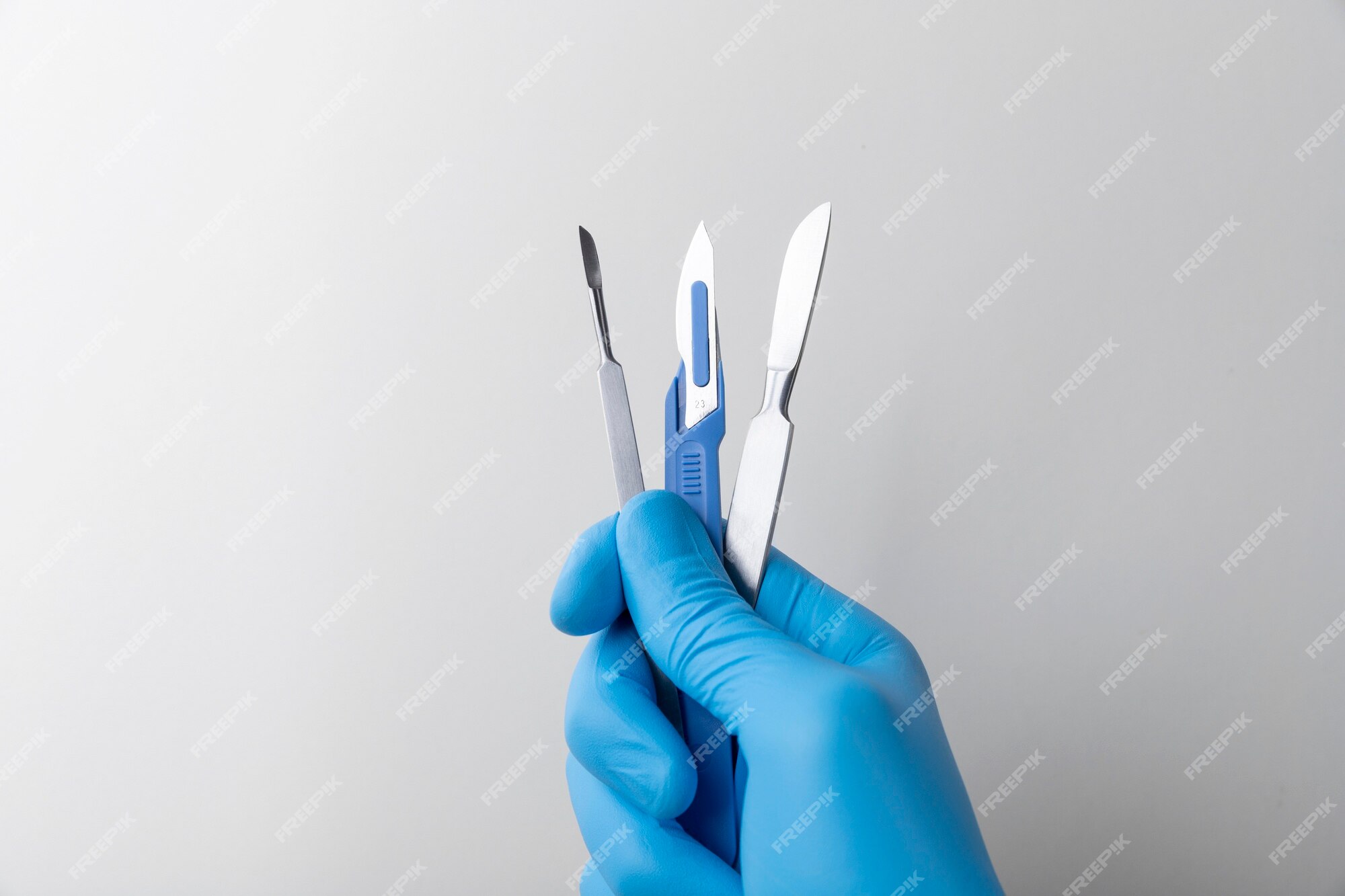 Free Photo | Hand with rubber glove holding medical scalpel