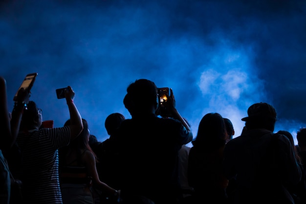 Hand with a smartphone records live music festival, taking photo of concert stage Premium Photo