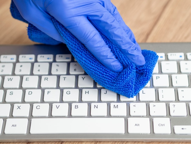 布でキーボードを洗浄する外科用手袋の手 無料の写真