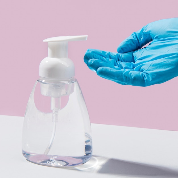 Premium Photo | Hand with surgical glove using hand sanitizer