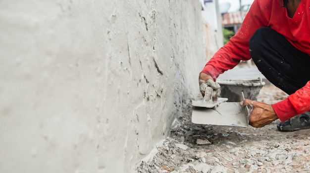 Premium Photo | Hand of worker plastering cement at wall for building ...