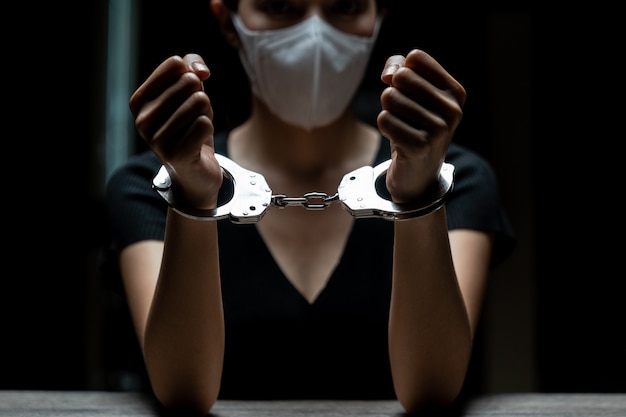 囚人に手錠をかけられた女性囚人は 暗い刑務所で手錠をかけられていた プレミアム写真