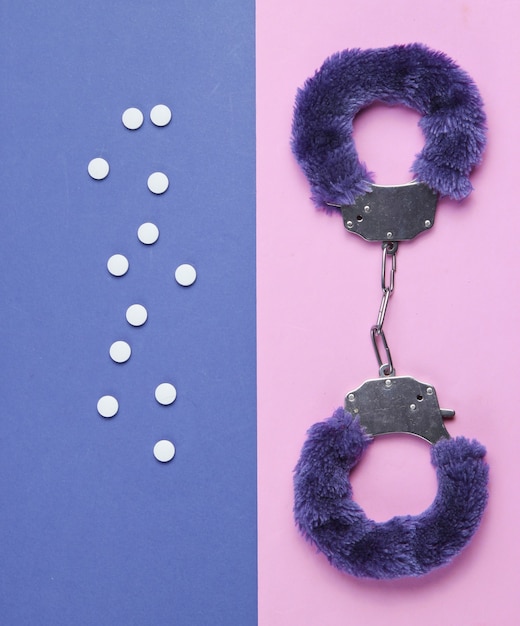 Premium Photo Handcuffs For Sex Games With Pills On Purple Pink