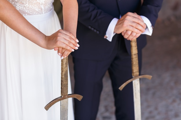 Premium Photo Hands Of The Bride And Groom Holding Swords During The   Hands Bride Groom Holding Swords During Wedding Ceremony 79762 4117 