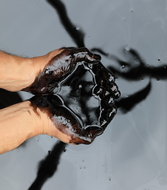 Premium Photo | Hands in crude black petroleum