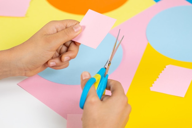 Premium Photo | Hands cuting colored paper with scissors education ...