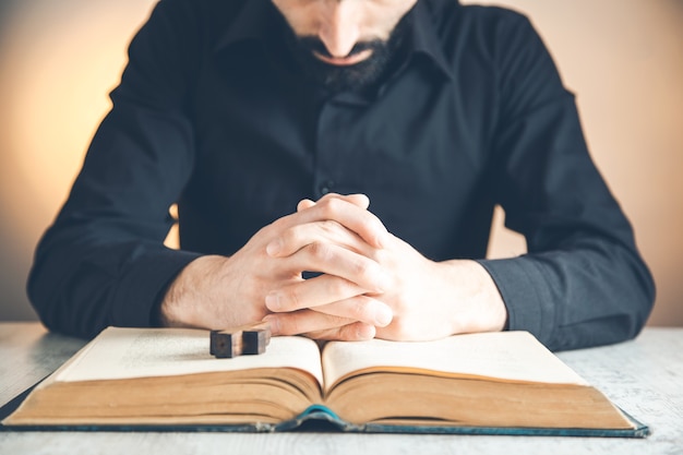 Premium Photo Hands Folded In Prayer On A Holy Bible In Church