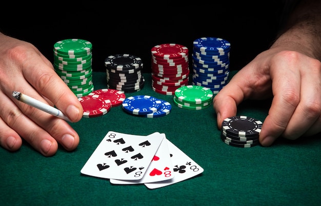 Premium Photo | Hands of a gambler closeup and chips on green table in ...