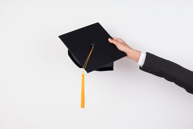 The hands of graduates holding a hat to throw a hat on isolated background. Premium Photo