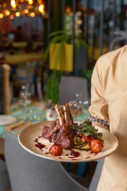 Premium Photo | Hands holding cooked tomahawk long bone ribeye steak on ...