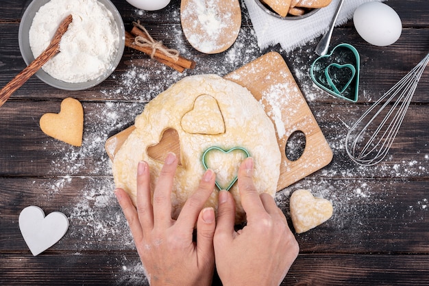 Mani Che Producono I Biscotti In Forma Di Cuore Di San Valentino Con Gli Utensili Della Cucina Foto Gratis