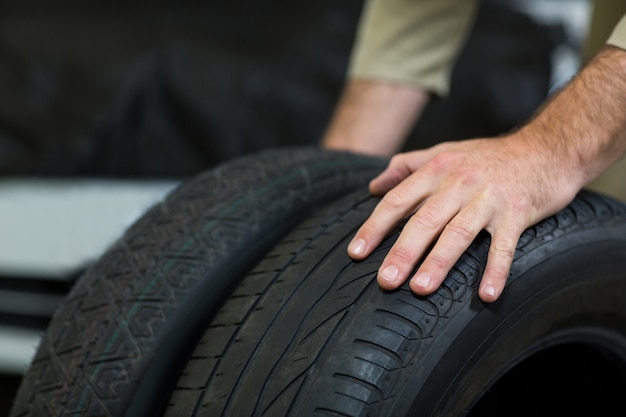 Free Photo | Hands of mechanic touching tyres