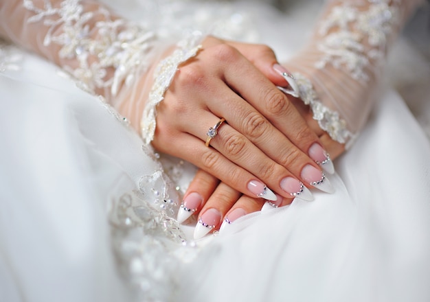 指輪と結婚式のマニキュアを持つ花嫁の手 プレミアム写真