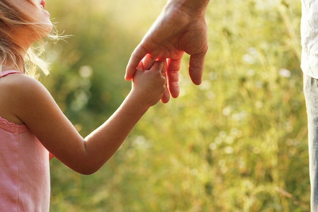 Premium Photo Hands Of Parent And Child Outdoors In The Park