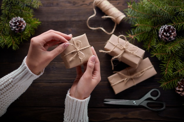 Hands tying the knot of string of gift packages Free Photo