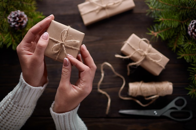 Hands tying the knot of string of gift packages Free Photo