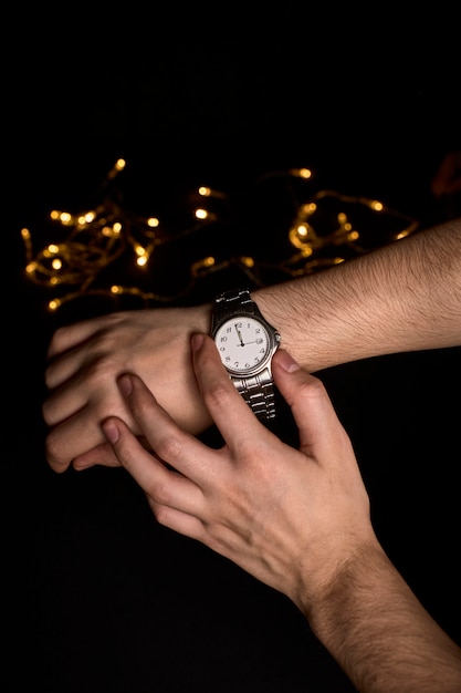 Hands of a young person looking at a clock about to mark the first second of the new year 2019 Premium Photo