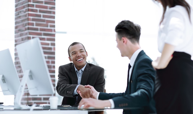 Premium Photo | Handshake international business partners on a desk