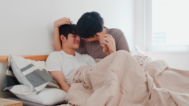 Handsome Asian Gay Couple Talking On Bed At Home Young