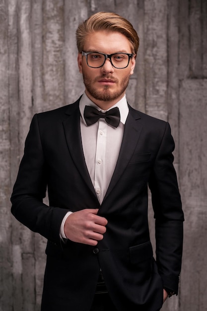 Premium Photo Handsome And Classy Handsome Young Man In Formalwear And Bow Tie Adjusting His 