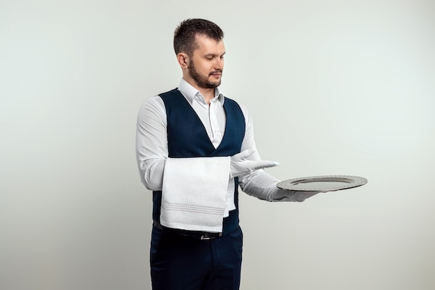  Handsome male waiter, in white shirt, holding a silver tray. the concept of serving staff serving c