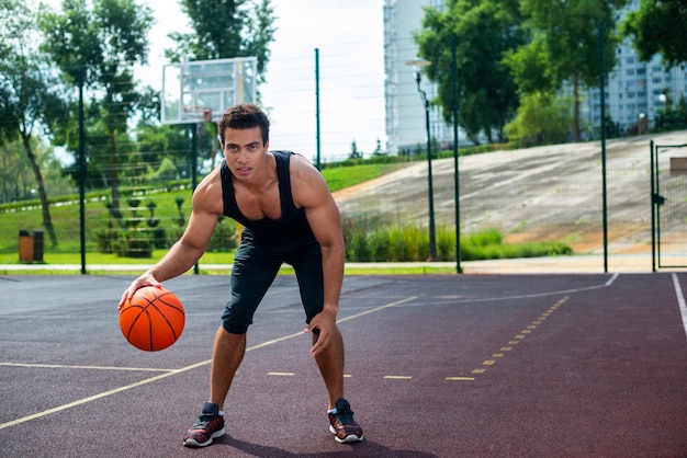 Free Photo | Handsome man playing with the basketball ball