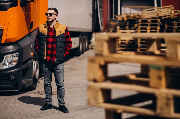 Free Photo Handsome Man Truck Driver Standing By The Truck