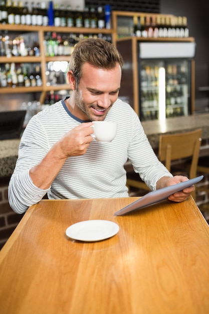 Handsome man using tablet computer and having a coffee Premium Photo