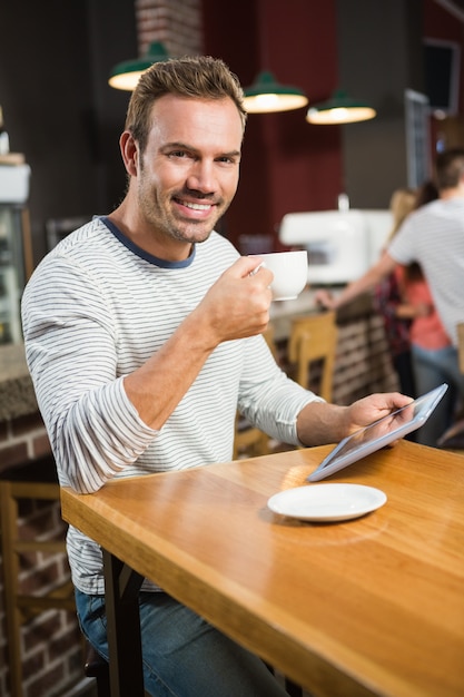 Premium Photo Handsome Man Using Tablet Computer And Having A Coffee 8883